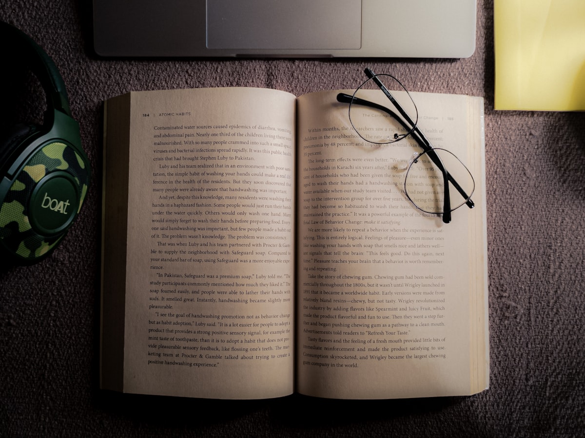 Open book next to a laptop for reading outreach guides